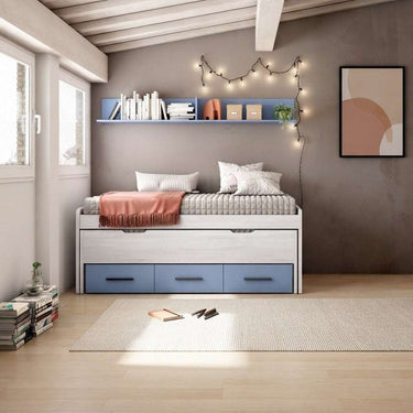 Cama compacta blanca con estructura de melamina, cama superior y tres cajones azules; Armario corredero no visible.
