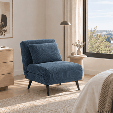 Butaca cama de tela azul acanalada, con respaldo acolchado y patas metálicas negras; diseño compacto y moderno.
