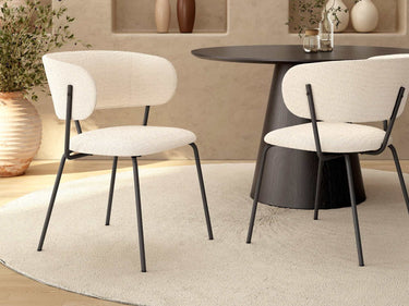 Butaca tapizada en color nácar con patas metálicas negras, asiento y respaldo acolchados, diseño moderno y minimalista.