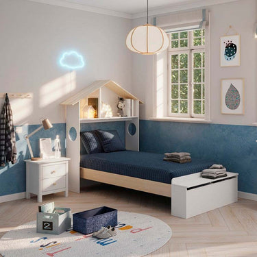 Cama infantil blanca de material laminado con detalles de madera natural, cabecero en forma de casita y arcón integrado.
