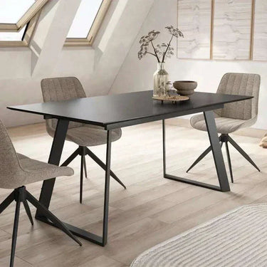 Mesa comedor extensible ROMINA PIEDRA con acabado efecto piedra y patas metálicas negras.