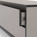 Mueble TV in matte taupe melamine with sleek, handleless cabinet fronts and a dark charcoal top and frame.