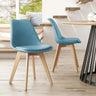 Silla de comedor tapizada en azul con respaldo curvo, asiento acolchado y patas de madera clara.