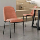 Silla de comedor ATLANTA en tono salmón, tapizada con asiento y respaldo mullidos y patas metálicas negras.