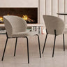 Silla de comedor tapizada en tejido gris jaspeado, con respaldo envolvente y patas de hierro negro.