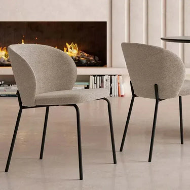 Silla de comedor tapizada en tejido gris jaspeado, con respaldo envolvente y patas de hierro negro.