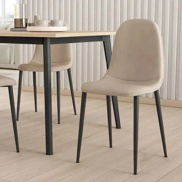 Silla de comedor beige tapizada en tela lisa, con respaldo curvo y patas metálicas negras sin reposabrazos.