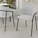 Silla de comedor tapizada gris claro con respaldo curvado y patas metálicas negras de diseño moderno y elegante.