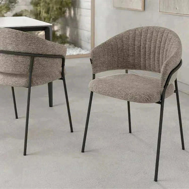 Silla de comedor tapizada gris con respaldo curvado y patas metálicas negras de diseño moderno y líneas finas.
