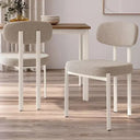 Silla de comedor tapizada color nácar con patas blancas metálicas, asiento y respaldo acolchados para mayor comodidad.