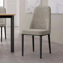 Silla de comedor tapizada en tejido gris jaspeado, con respaldo alto y patas metálicas negras delgadas.