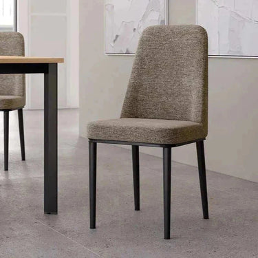 Silla de comedor OSLO tapizada en tejido gris topo con respaldo alto y patas metálicas negras delgadas.