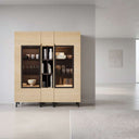 Vitrina de comedor en madera clara melamínica, con dos puertas acristaladas y estantería central estrecha.