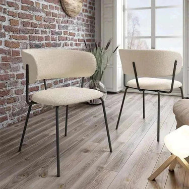 Butaca tapizada color nácar con patas metálicas negras, diseño minimalista y respaldo acolchado, ideal para salón moderno.