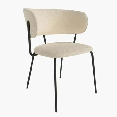 Butaca tapizada en color nácar con asiento y respaldo acolchados, patas metálicas negras y diseño estilizado.