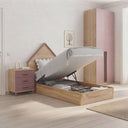 Cama juvenil abatible de madera clara con cabecero en forma de casita, mesita de tres cajones y armario rosa de dos puertas.