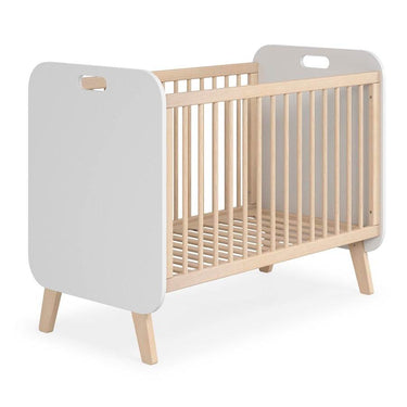 Cuna infantil de paneles blancos y estructura de madera clara, con barrotes verticales, patas inclinadas y somier de láminas.