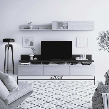 Mueble salón modular en acabado blanco y gris oscuro, con líneas minimalistas, panel para TV, estante y módulo superior con puerta.