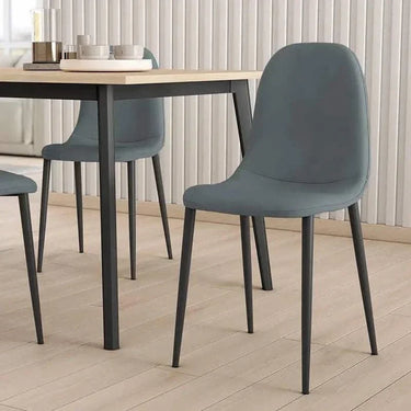 Silla de comedor gris de microfibra con respaldo curvo, asiento acolchado y patas metálicas negras sin reposabrazos.