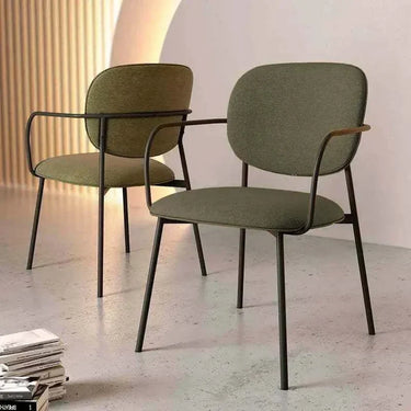 Silla de comedor tapizada verde con reposabrazos y patas metálicas negras, diseño moderno y confortable.