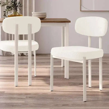 Silla de comedor tapizada color nácar con patas blancas y diseño moderno, ergonómica y acolchada para confort.