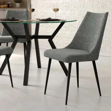 Silla de comedor gris con asiento y respaldo tapizados en tejido y patas metálicas negras; diseño moderno de líneas curvas.