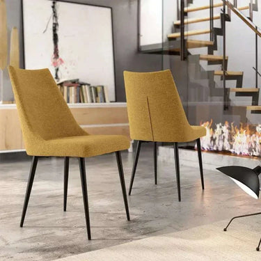 Silla de comedor tapizada en mostaza, con respaldo curvo y patas metálicas negras de diseño moderno.