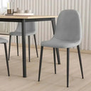 Silla de comedor gris en microfibra suave, con asiento curvo sin reposabrazos y patas metálicas negras.