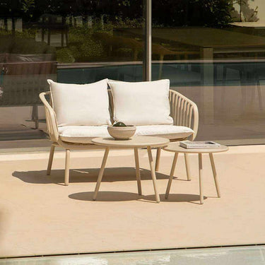 Sillón de jardín Abura con cojines beige en terraza moderna