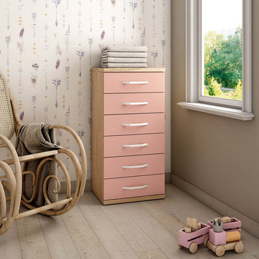 Xifonier de seis cajones con estructura de madera clara, frentes rosa empolvado y tiradores blancos alargados.